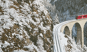 Train in swiss country side with snowy mountains