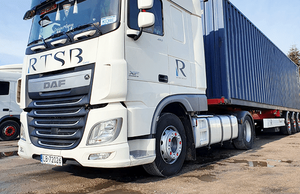 white parked RTSB container truck carrying a blue container.